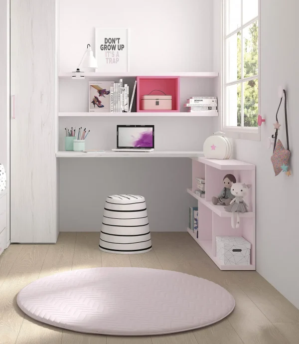 Zona de estudio infantil combinada en laminado claro y rosa con una mesa de estudio a medida,estantes a pared y estanteria a suelo irregular en color rosa