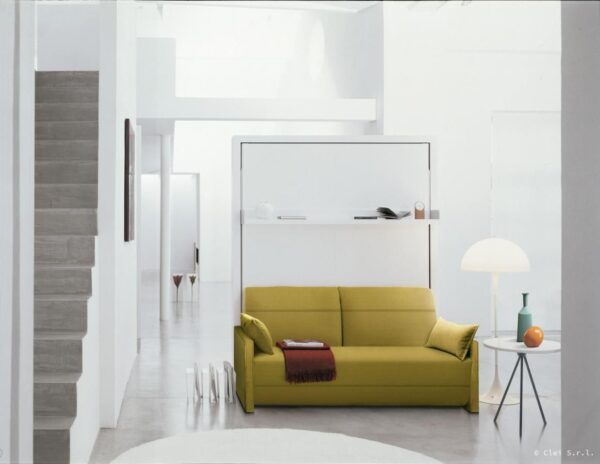Cama abatible vertical de matrimonio blanca con un sofá delante con relax en color verde