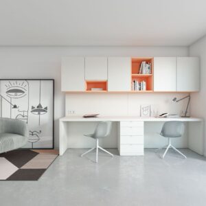 Mesa de estudio a medida blanca con una cajonera enmedio y arriba colgados modulos de puerta y huecos combinados ne naranja
